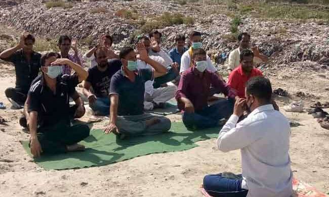 मुंह पर मास्क लगाकर अनूठे तरीके से कूड़े के ढेर पर किया योग